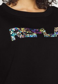 Černá mikina s holografickým logem "REFL" a barevnými, třpytivými vzory, širokým zaobleným výstřihem.