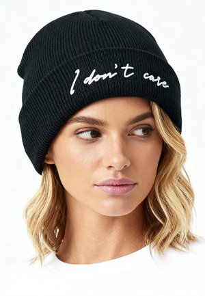 Black ribbed beanie featuring white embroidered text "I don't care." Text is centered on the front, with a soft, textured appearance.