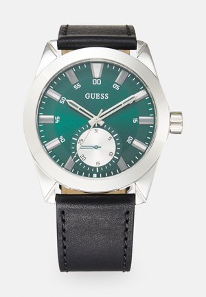 Muška analogna sat s kućištem od srebrnog nehrđajućeg čelika, zelenim brojčanikom, crnim kožnim remenom i podbrojčanikom koji prikazuje datum.