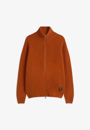 Orange ribbed knit zip-up sweater with a high collar, featuring diagonal knit patterns and a branded label at the bottom left.