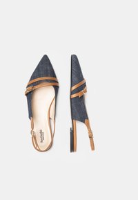 Denim slingback sko med spids tå, brune stropper, justerbar spænde og lille hæl. Har en beige indersål og minimalistisch design.