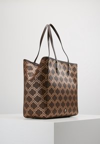 Brązowa torebka typu tote o wzorzystym, usztywnionym kształcie, z wąskimi skórzanymi uchwytami i subtelnym wytłoczonym wzorem. Wzbogacona małym logo.
