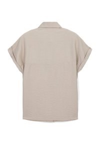 Camicia beige a maniche corte con tessuto testurizzato, colletto a punta e vestibilità ampia. Presenta una cucitura orizzontale sulla schiena.