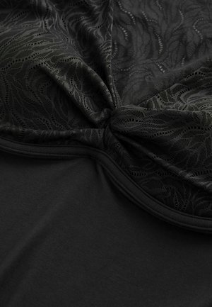 Černý top s texturovaným krajkovým překryvem se vzorem listů, středovým záševkem a hladkým pevnějším základem.