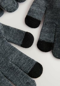 Graue Strickhandschuhe mit schwarzen Fingerspitzen, die aus einem strukturierten Stoff gefertigt sind und eng anliegen. Jeder Finger weist ein deutliches Muster mit kontrastierenden Farben auf.
