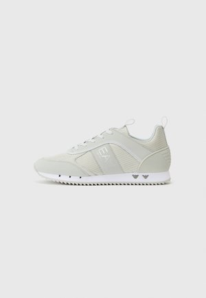 Jasnoszare buty sportowe, wykonane z siateczkowych i syntetycznych materiałów, z zapięciem na sznurowadła, wyraźnym logo po boku oraz teksturowaną białą podeszwą.