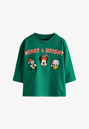 Camiseta de algodón verde con un corte oversize, cuello redondo y personajes de Disney bordados con sombreros festivos, etiquetada "FELIZ Y BRILLANTE".