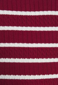 Tissu tricoté présentant une base rouge profond avec des rayures blanches texturées alternées et un motif de tricot en torsade, créant une apparence côtelée.