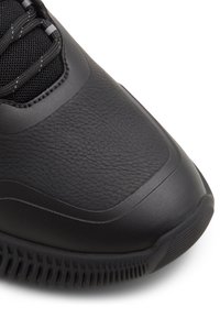 Sneaker neri realizzati in materiale sintetico testurizzato. Presentano dettagli in rete, collare imbottito e suola in gomma con motivo rigato.