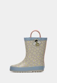 Children's rubber rain boot with a light beige background, yellow daisies, blue top, pink handle, and a bee graphic on the side.