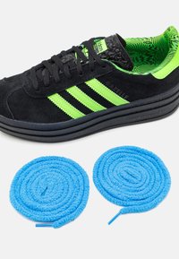Black suede sneaker with green three stripes and textured black accents. Includes two blue plush shoelaces in a spiral shape.