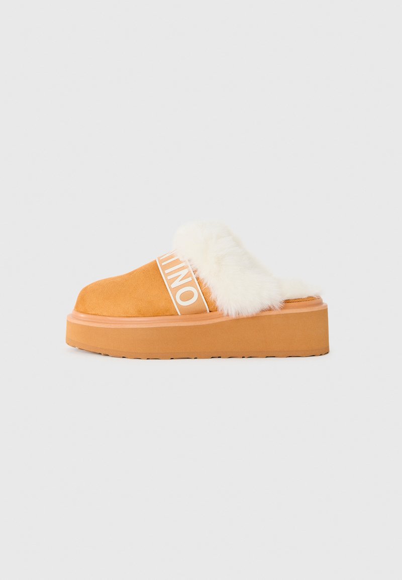 Brun plattform slip-on sko med hvit fôr og synlig merkevare-elastisk stropp på hvit bakgrunn.