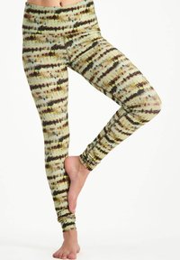 Flerfärgade leggings med ett tie-dye-mönster i nyanser av grönt, brunt och gult. Tillverkade av stretchigt, åtsittande tyg med hög midja.