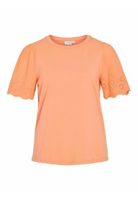 Camiseta color durazno con mangas cortas de globo. Las mangas tienen un borde en forma de ondas y patrones de ojales bordados. Material de algodón suave.