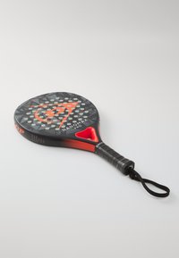 Padel-Schläger mit einem schwarzen und roten Design, ausgestattet mit einem strukturierten Griff und einem runden Griff, verziert mit kontrastierenden Punkten und einem zentralen Logo.