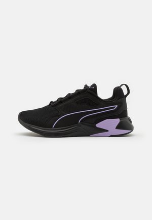 Black athletic shoe made of mesh and synthetic materials. Features purple accents, textured sole, and a lace-up closure.