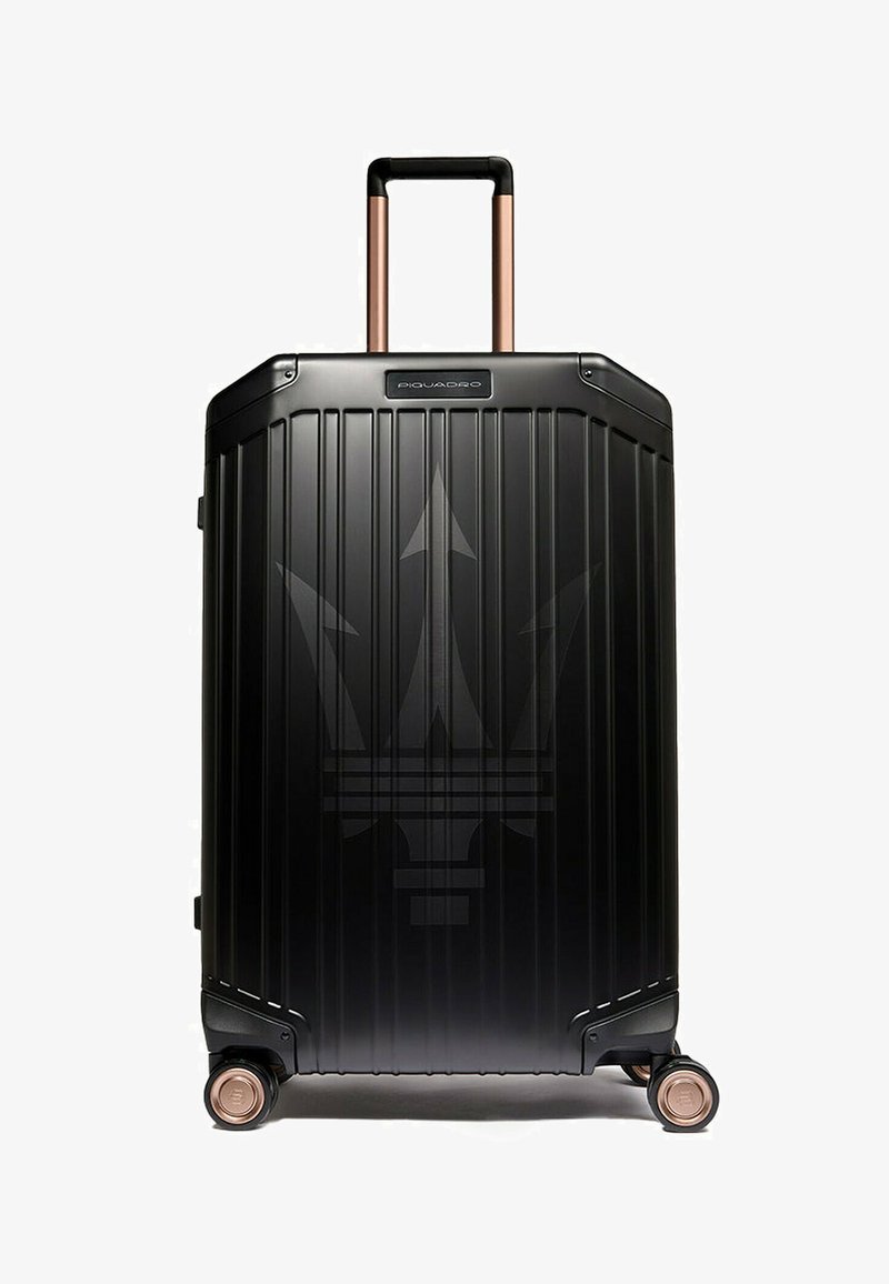 Schwarzer Hartschalen-Koffer mit vertikalen Rillen, kupferfarbenem Griff und Rollen. Verfügt über ein dezentes Logo auf der Vorderseite.