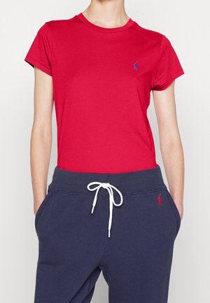 Czerwona bawełniana koszulka z krótkimi rękawami i okrągłym dekoltem, zestawiona z granatowymi spodenkami dresowymi z regulowanym sznurkiem i detalem z logo.