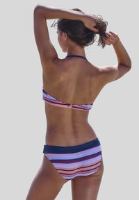 Bikini rinkinys su daugiakompleksio dryžuotu raštu, derinančiu rožinę, violetinę ir tamsiai mėlyną spalvas, su kaklo juostele ir palaikančia nugaros užsegimu.