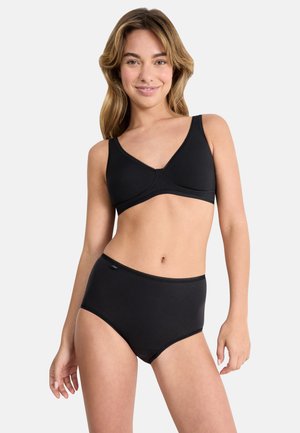 Sort bomulds-bralette med V-hals design og justerbare stropper, kombineret med sorte, højtaljede bomulds-trusser. Glat tekstur, minimal detaljering.