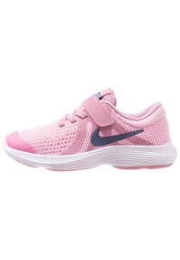 Růžová dětská sportovní obuv s suchým zipem, síťovaným svrškem, bílou podrážkou a tmavým logem Nike swoosh.