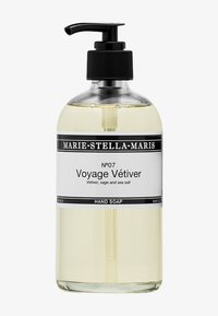 Genomskinlig flaska med svart pumpdispenser som innehåller ljusgul handtvål märkt Marie-Stella-Maris Voyage Vétiver, med doft av vetiver, salvia och havssalt.