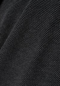 Close-up van zwart textuurstof met een geweven patroon dat fijne details en diepte in het textieloppervlak laat zien.