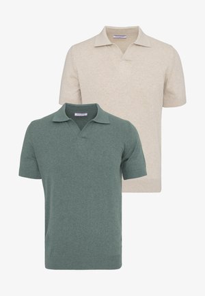 Dos polos de manga corta con cuello, uno beige y otro verde apagado, mostrados superpuestos sobre un fondo blanco.