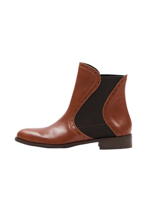 Bottine en cuir marron avec des panneaux latéraux élastiques, bout rond et perforations décoratives le long des bords. Talon bas.