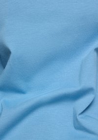 Light blue fabric with soft, subtle folds and fine knit texture, showing natural drape and slight shadows.