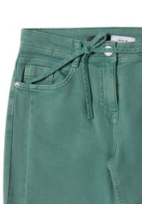 Pantalones de mezclilla verdes con cierre de lazo, bolsillos frontales y un acento de botón plateado. La tela tiene un acabado suave y texturizado.