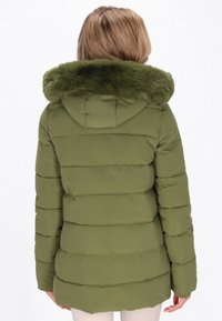 Jachetă puffer verde măsliniu cu guler din blană artificială, având un design ușor, matlasat și o siluetă ajustată, văzută din spate.