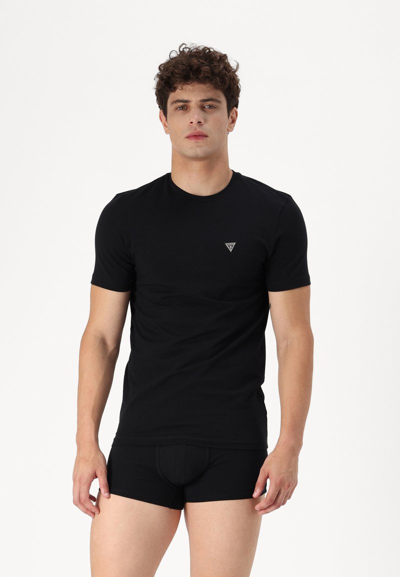 Svart bomulls t-skjorte med korte ermer, rund hals og diskret trekantet logo på brystet, sammen med matchende svarte boxershorts.