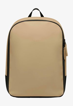 Beige rugzak met een gladde, matte afwerking. Heeft een zwarte rits aan de zijkant, een handvat aan de bovenkant en een reliëflogo. Rechthoekige vorm. Minimalistisch ontwerp.