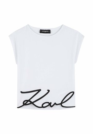 Camiseta blanca de manga corta con cuello redondo amplio y gran texto cursivo negro "Karl" bordado cerca del dobladillo inferior.