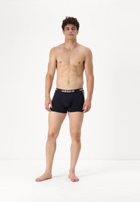 Svart herreboxerbriefs har en merket elastisk midje. Tøyet ser glatt og tettsittende ut, uten synlige mønstre eller detaljer.