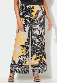 Široké kalhoty z lehké tkaniny s černým, žlutým a béžovým květinovým vzorem, s dekorativním černým lemem na spodním okraji.