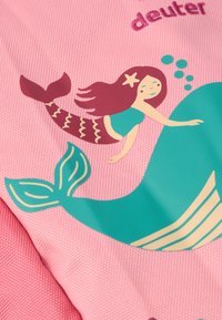 Prodotto tessile rosa con un design di sirena e balena in verde acqua e marrone. Include dettagli a bolle e il nome del marchio "deuter."