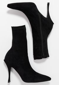 Svarta mockasins stövletter med spetsiga tår, höga stilettklackar och sidogliffrar, med en slät yta och passande silhuett.