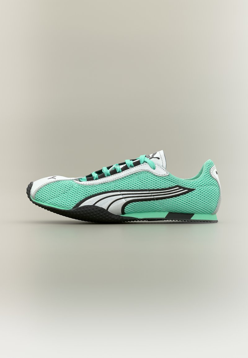 Αθλητικό παπούτσι με χαμηλό προφίλ σε πράσινο μέντας πλέγμα με λευκές και μαύρες λεπτομέρειες, απεικονίζεται από τη μεριά σε ουδέτερο φόντο.