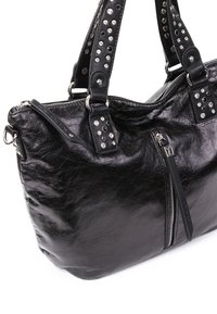 Sac à main en cuir noir avec des clous argentés sur les doubles poignées, poche zippée verticale à l'avant et une surface texturée brillante.