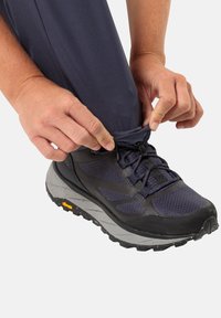 Schwarzer und marineblauer Wanderschuh mit einem strukturierten Mesh-Obermaterial, Gummisohle und gesprenkelter grauer Zwischensohle. Zugband zum Festziehen für einen sicheren Sitz.