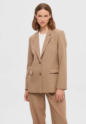 Blazer beige realizzato in tessuto strutturato, caratterizzato da revers a punta, due tasche frontali, chiusura a bottoni e una vestibilità comoda.