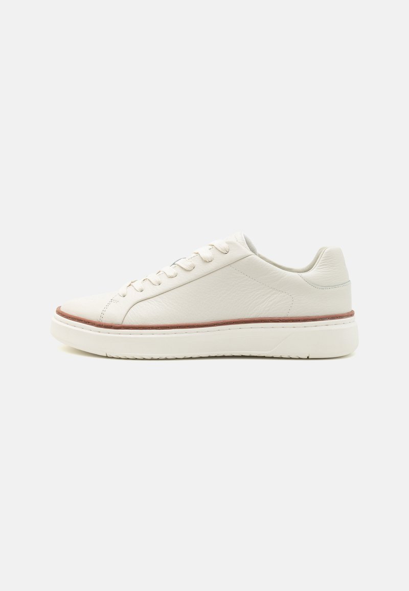 Weißes Leder-Sneaker mit strukturiertem Finish, niedrigem Profil, runder Spitze, fünf Ösen und einem subtilen braunen Akzent an der Sohle.