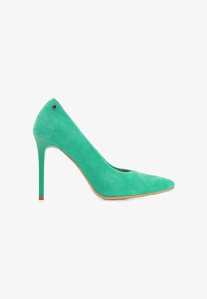 Escarpin en daim turquoise à talons hauts avec bout pointu et talon stiletto fin, vu de profil sur fond blanc.