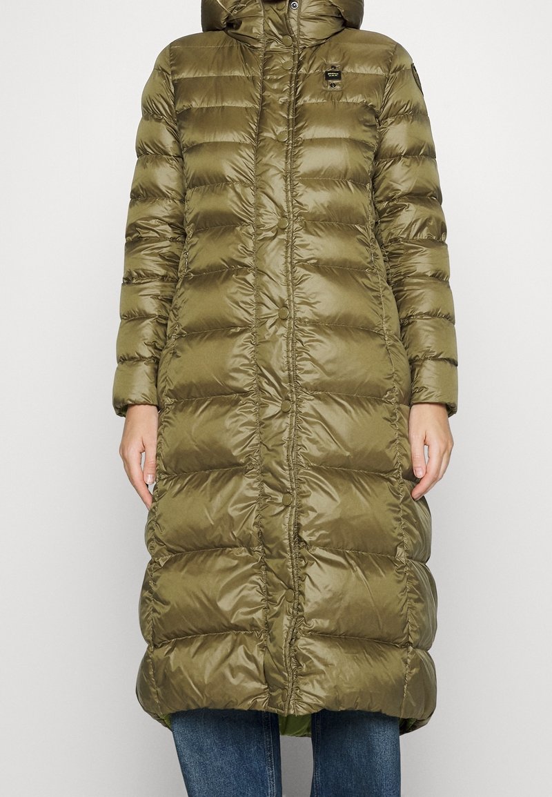 Abrigo acolchado de color verde oliva, con capucha, cierre de botones y diseño acolchado. Hecho de material brillante y suave con una silueta larga.