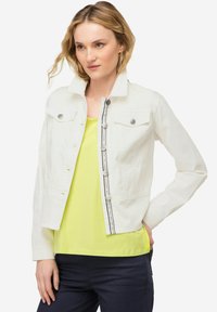 Weiße Jeansjacke mit Kragen, Fronttaschen und silbernen Knöpfen; verfügt über einen zentralen Reißverschluss und dekorative Steppnähte.