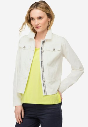 Witte denimjack met een kraag, voorzakken en zilveren knopen; heeft een centrale rits en decoratieve stiksels.