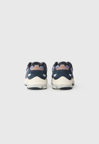 Sneakers med en marineblå og lavendel overdel, lavet af ruskind og mesh-materialer, med en cremefarvet sål og synlige støtdæmpningselementer for støtte.