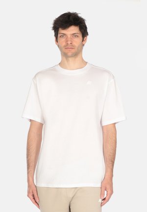 T-shirt bianco in cotone a maniche corte con colletto rotondo e un logo discreto sul lato sinistro del petto. Vestibilità rilassata e tessuto di spessore medio.